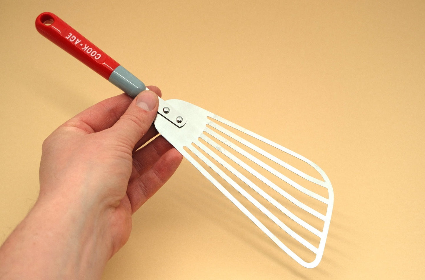 Slotted flexible spatula with a plastic handle