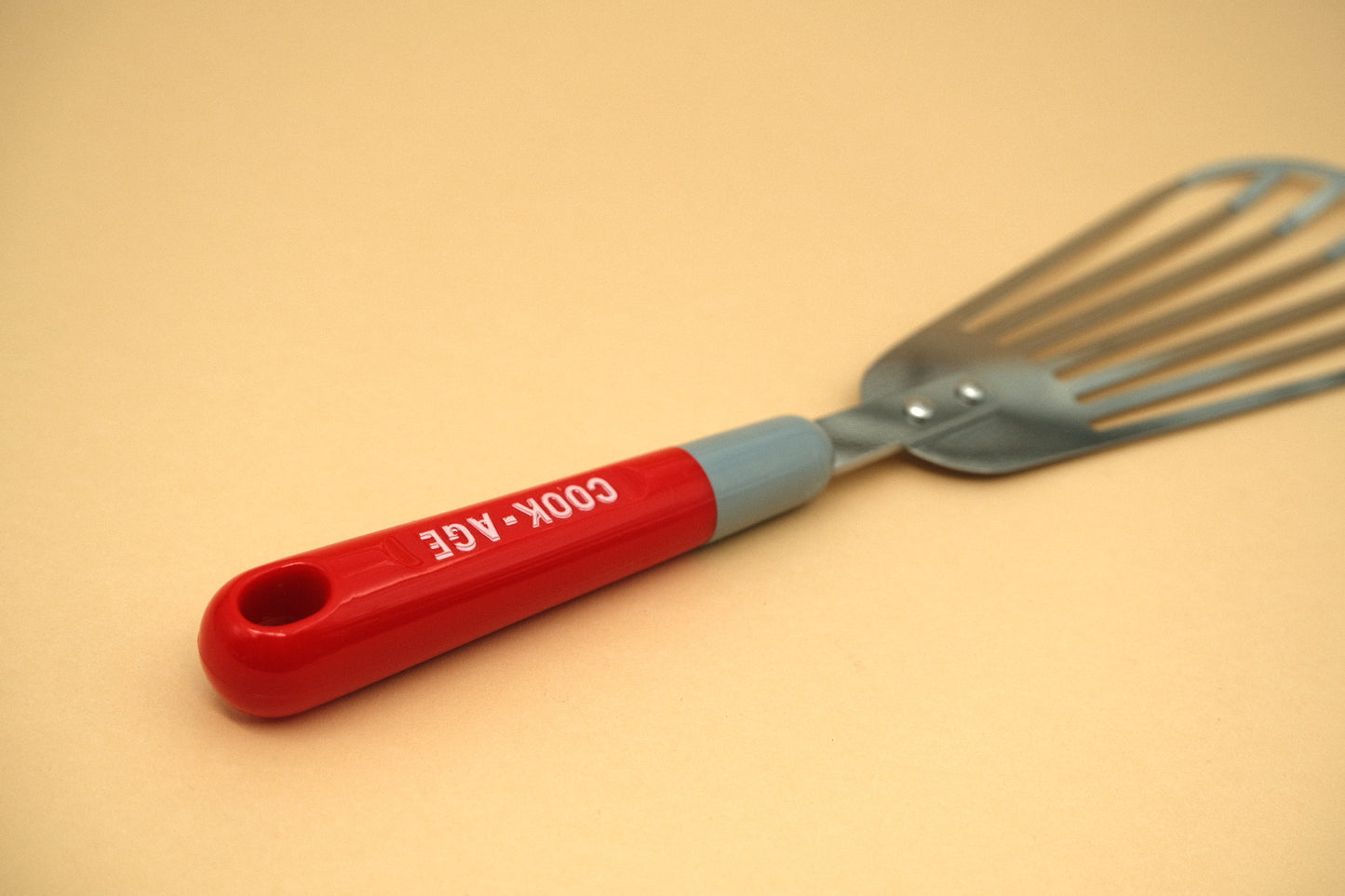 Slotted flexible spatula with a plastic handle