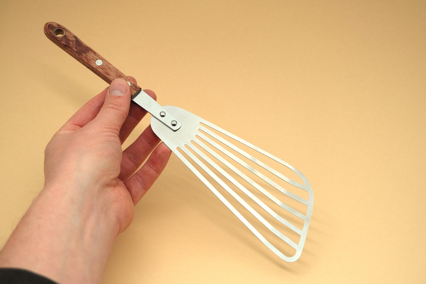 Slotted flexible spatula with a pakka handle