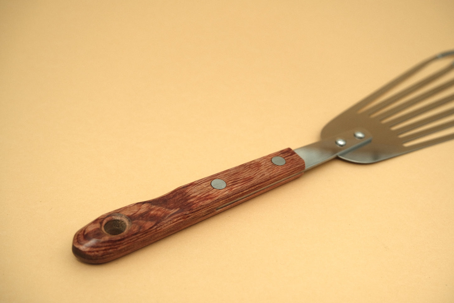 Slotted flexible spatula with a pakka handle